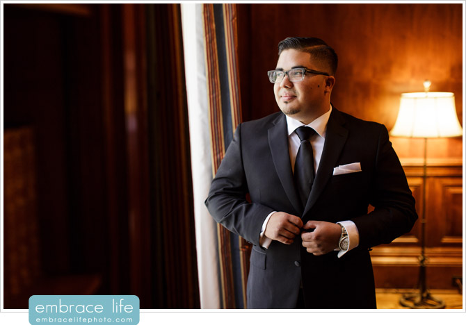 Groom Portrait at Athenaeum library buttoning suit jacket