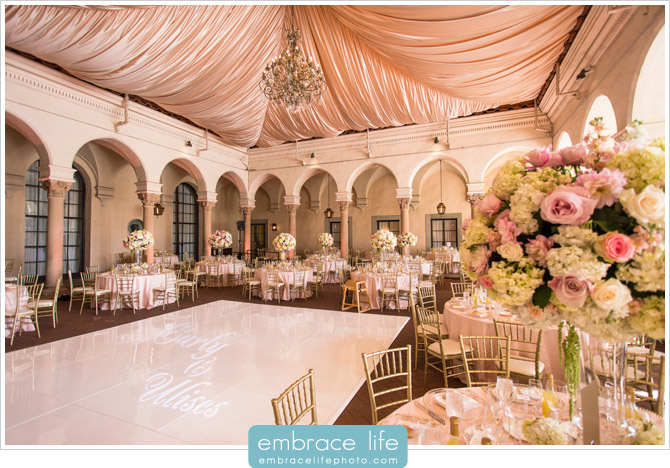 Gorgeous wedding reception featuring blush draping and custom monogram on white dance floor