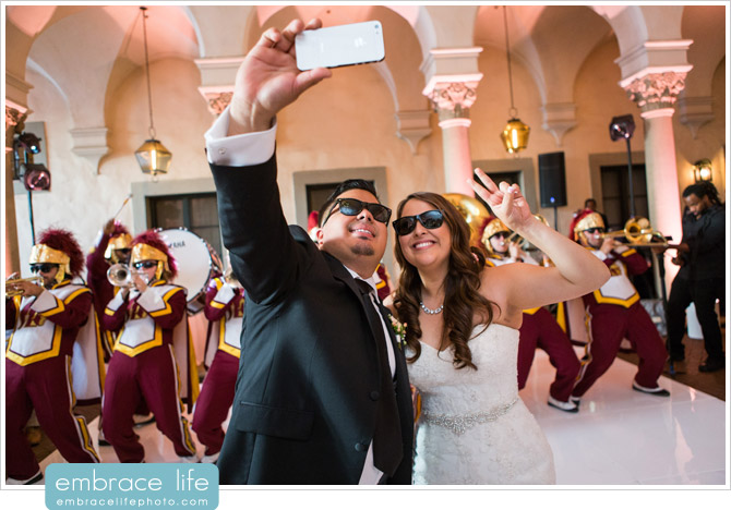 Bride and Groom taking selfie with USC Marching Band at their wedding reception